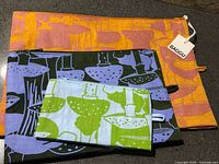 Three Baggu Go Pouches in different colors with mushroom prints, retail tag visible