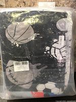Sealed package showing folded bedding with sports graphics and barcodes