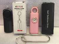 Both alarm units standing with their respective boxes and key clip