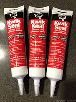 Front view of three sealed tubes of DAP Kwik Seal adhesive caulk