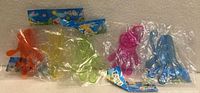 Five packaged sticky slap hands in various colours showing typical appearance