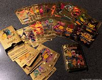 Spread of numerous gold foil Pokémon cards with one opened box and one sealed box