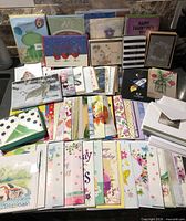 Overview of numerous stacks of unused greeting cards and envelopes spread on countertop