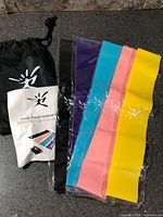 Five sealed resistance bands, drawstring pouch and instruction leaflet displayed on countertop