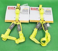 Two packaged neon yellow LED dog harnesses front view