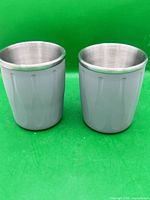 Two grey double-wall stainless steel mugs side by side