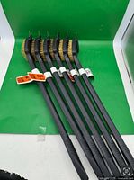 Six identical grill brushes laid out