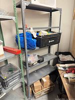 Full view of grey metal shelving showing four shelves and upright posts