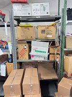 Front view of grey metal shelving with five shelves, contents visible but not included