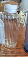 clear ribbed glass pitcher, partial view of plastic pitcher