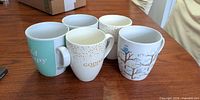 Group shot of all five mugs showing designs and quantity