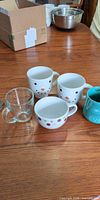Group of five assorted mugs on table