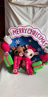 Front view of entire plush wreath showing Rudolph, Clarice, Merry Christmas text, stockings and gift box accents