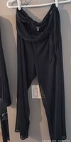 Full view of black chiffon pants on hanger
