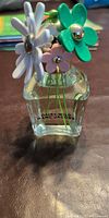 Front view of perfume bottle showing cap with multicolor daisies and Marc Jacobs branding