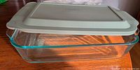 Side view of clear glass rectangular Pyrex dish with mint lid