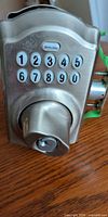 Front view showing Schlage keypad with numbers 1-9 and 0, key cylinder and satin nickel finish