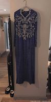 Full view of blue beaded long evening dress hanging