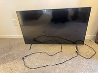 Front view of Samsung TV with stand and power cord