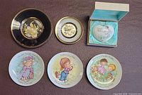 All six items arranged—two Chokin plates, boxed Noritake heart, three Avon plates