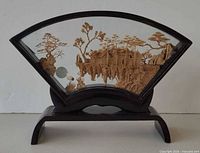 Full view of fan-shaped carved glass display on stand