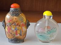 Front of both snuff bottles showing painted scenes and stoppers