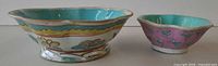 Side view of both bowls showing exterior enamel decoration and relative sizes