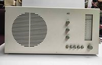 Front view showing speaker grille, control knobs and dial