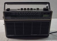 Front view showing speaker grille, model branding and tuning scale