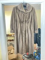 Front view of mink fur coat on hanger