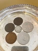 Group of six coins in dish