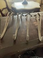 Four curved metal brackets on tabletop