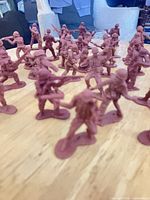 Close view of maroon plastic soldiers in various combat poses