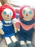 Both dolls seated together showing outfits and size perspective