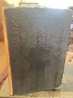 Front cover showing black embossed design and missing spine covering