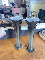 pair of tall coloured glass vases on table