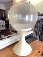 Full view of pedestal terrarium on wooden surface