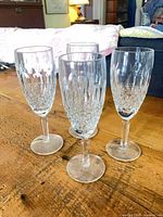 Four Waterford Colleen crystal champagne flutes on wooden table