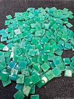 Pile of numerous square green onyx stones on dark surface