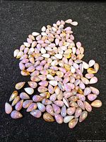 Pile of loose teardrop opals on black background