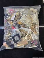 Full view of sealed plastic bag filled with assorted costume jewelry