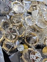 Pile of bagged gold-tone cases and assorted dials