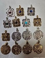 Group shot of all 16 pendants on cloth background