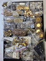 Overview of tray filled with multiple bags of assorted metal hardware components