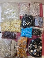 Overview of twelve bags of assorted cabochons and beads
