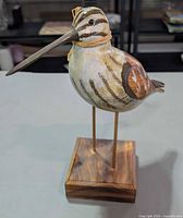Front three-quarter view of carved shorebird on stand