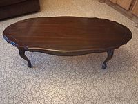 Top view of oval mahogany coffee table showing surface and scalloped edge