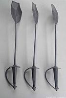 Three sword-style fly swatters full view showing hilts and blades