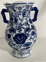 Front view of blue and white floral ceramic vase with handles