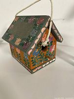 Angled view showing roof, walls, floral painting, rope hanger